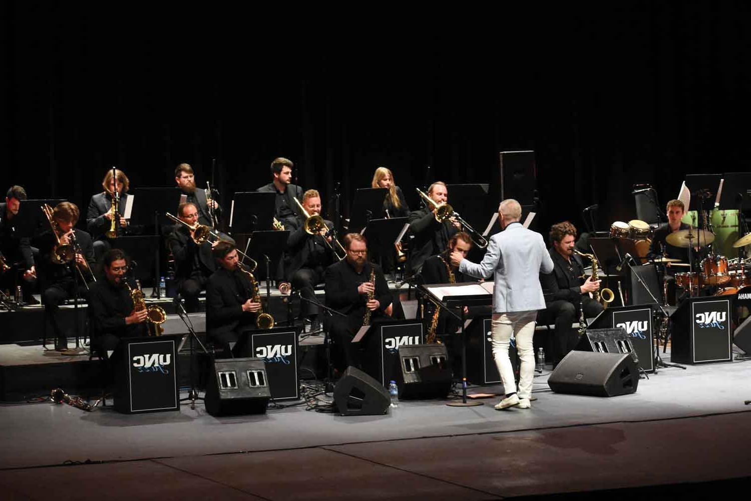 UNC students and conductor on stage.